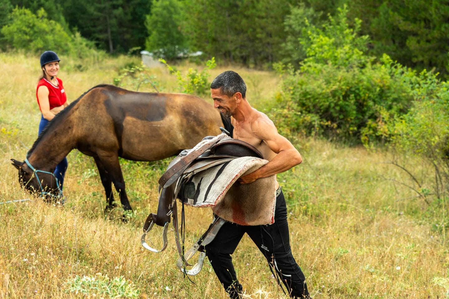 A guide unsaddling a horse after a day of riding in Albania