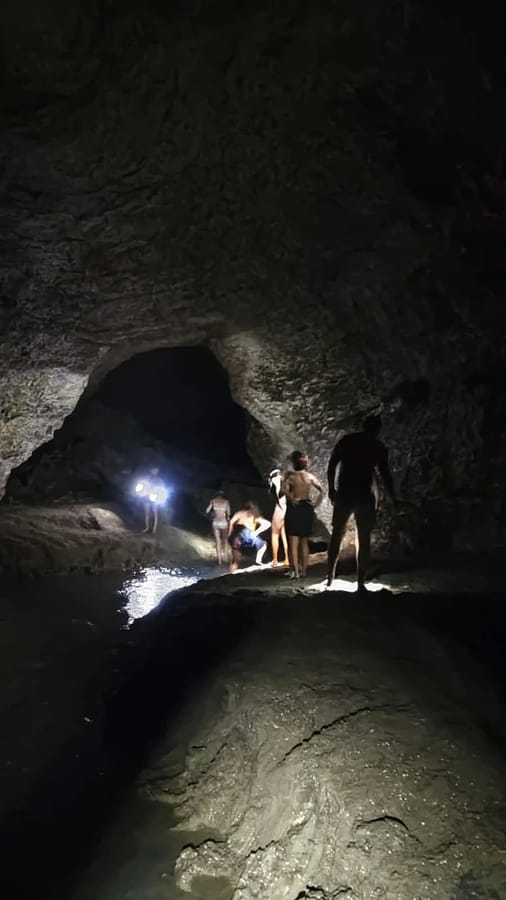 Exploring a cave with headlamps on the riding tour