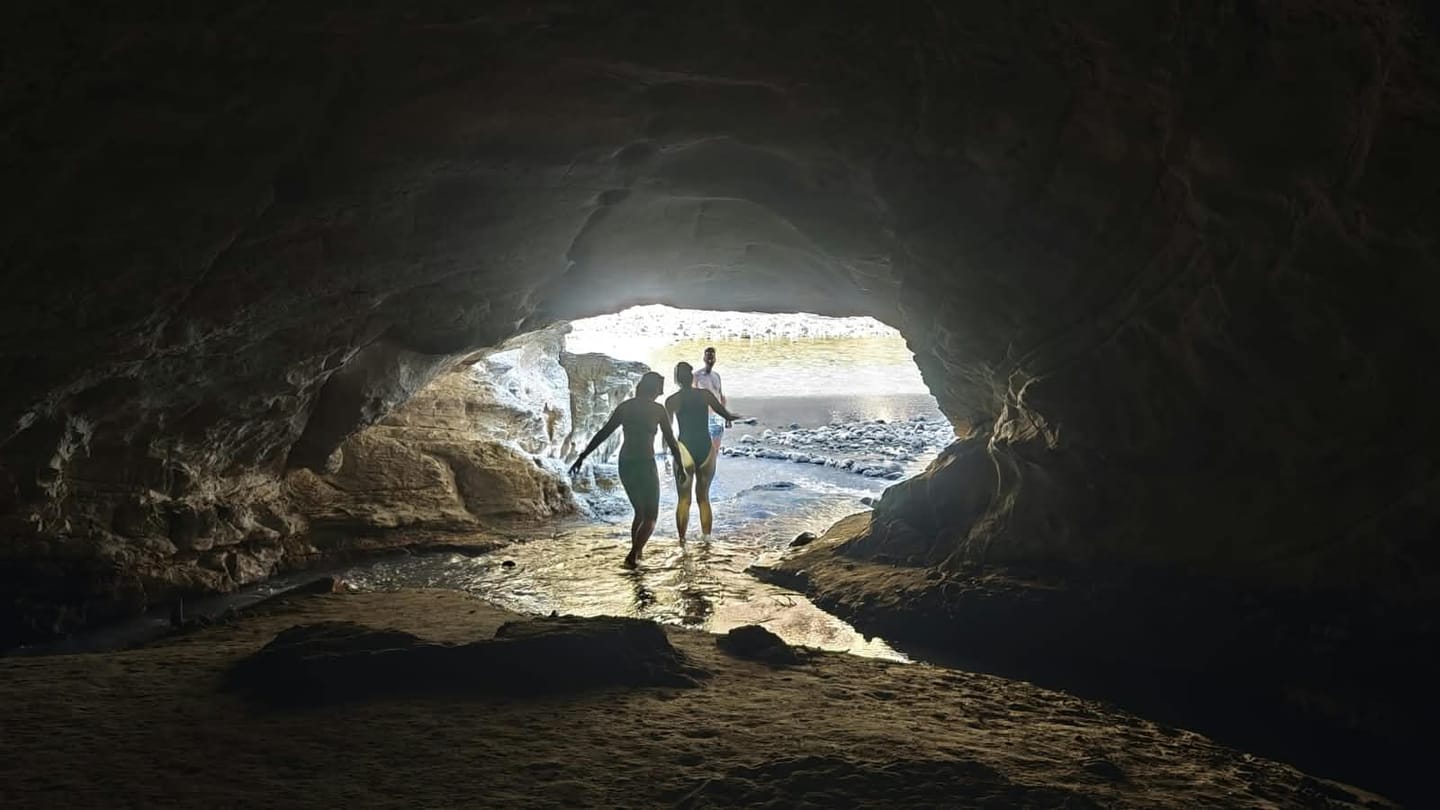 Two people at the entrance of a river cave